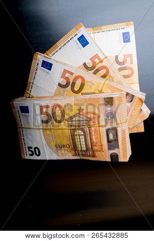 Pile Of 50 Real Euro Notes 50-euro Banknotes Under Rubber Band Isolated On Black. About 20000 Euros 