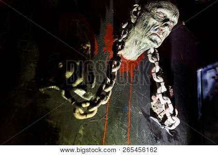 Ghost Head With Chains And Manacles Emerges From Wall