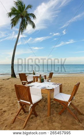 Outdside Dining Setup On A Tropical Beach With Palm Tree