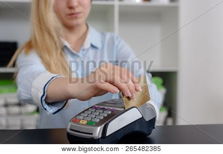 Administrator At Gym Using Payment Terminal For Paying By Credit Card