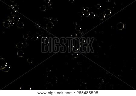 Shiny Air Bubbles Isolated Over A Black Background.
