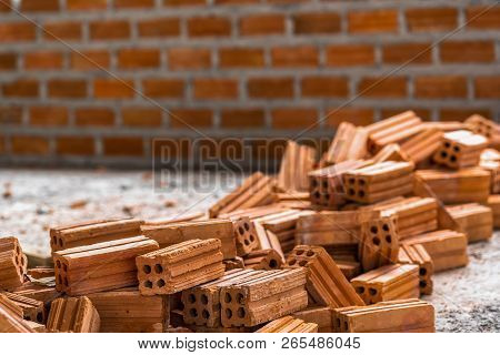 Stack Of Brick Preparing For Mansonry Over The Photo Blurred Of Bricks Wall Background,