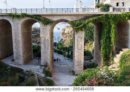 Polignano A Mare, Italy - July 6 2018: People On The Ponte Lama Monachile Bridge, Adriatic Sea, Apul