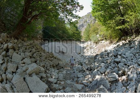 seinor male hiker relaxing in nature while  walking tour on beautiful summer day on canyon of  dried riverbed