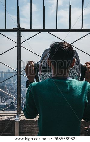 New York, Usa - May 29, 2018: Young Man Looking Using Binoculars On The Observation Platform At Empi