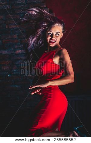 Joyful Dancing Woman  In Red Dress With Curly Hair
