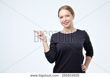 Young Elegant Woman In Black Pulover Pointing Aside