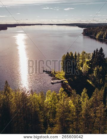 Small Pier At The Shore Of A Big Lake On A Evening With Sun Reflecting In The Water, Finland Suomuss