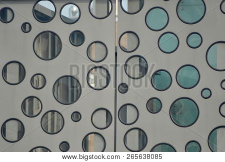 A Random Patterm Of Glass Circles (similar To Portholes) On A Door. The Door Is Grey, With The Circl