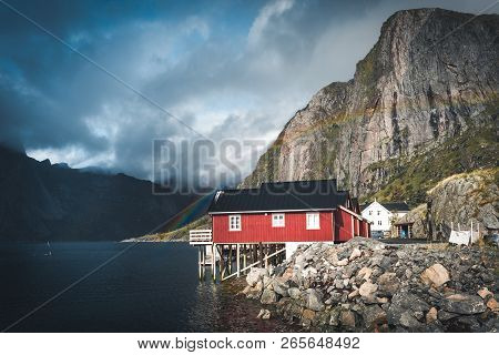 Rainbow Ofer Red Houses Rorbuer Of Reine In Lofoten, Norway With Red Rorbu Houses, Clouds, Rainy Blu