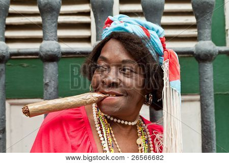 HAVANA-februar 10: rynket gammel dame med en kæmpe cigar bærer typisk tøj og afrocuban religiøse