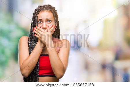 Young braided hair african american with pigmentation blemish birth mark over isolated background shocked covering mouth with hands for mistake. Secret concept.