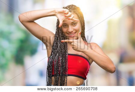 Young braided hair african american with pigmentation blemish birth mark over isolated background smiling making frame with hands and fingers with happy face. Creativity and photography concept.
