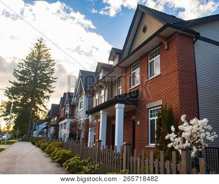 Row Of Typical English Terraced Houses. Red Brick Homes Side By Side.