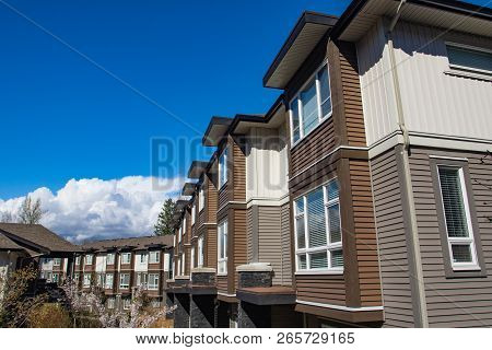 New Modern Low Rise Appartament Complex On A Sunny Spring Day With Blooming Sakura Trees.