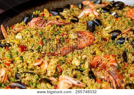 Seafood Paella With Rice, Tomato Sauce, Langoustine, Mussels, Squid, Shrimp.