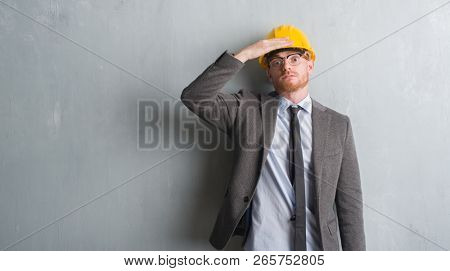 Young redhead man wearing architect outfit and helment stressed with hand on head, shocked with shame and surprise face, angry and frustrated. Fear and upset for mistake.