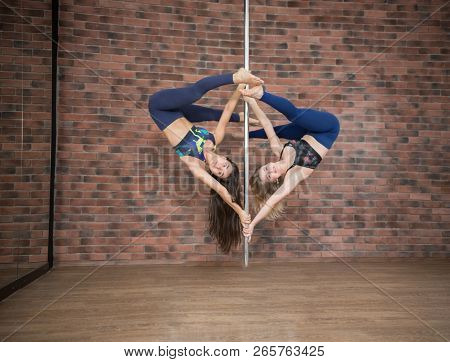Girls Posing On A Pylon In A Pole Dance Studio