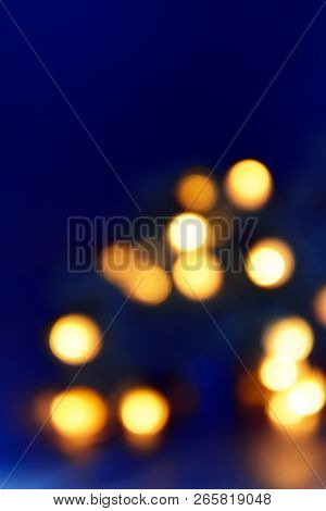 Background Of Blurry Blue-blue Lights Of The Christmas-tree Garland On The Dark. Copy Space.