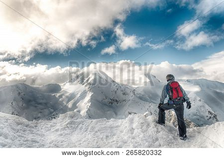 Skier Stay With Skis On Big Rock On Mountains Backdrop. Bansko, Bulgaria