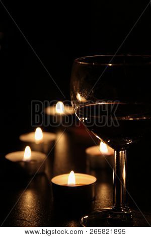 One Glass Of Wine In The Light Of A Multitude Of Candles