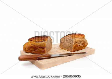 A Homemade Plumcake Standing On A Wooden Board With A White Background