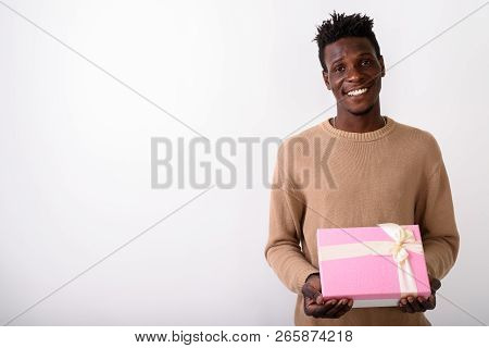 Studio Shot Of Young Happy Black African Man Smiling While Holdi