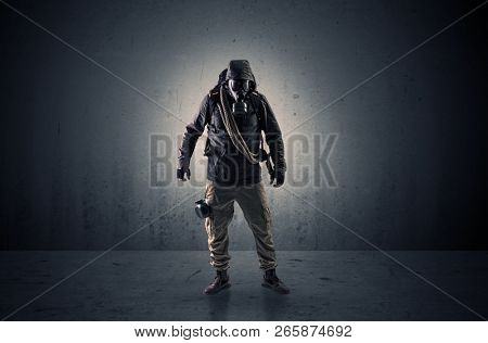 Bad agent in a dark room with arms on his hand and gas mask