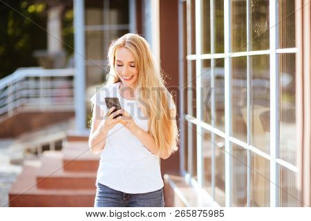Attractive Smiling Woman Using Smartphone Outdoors. Lefestyle Concept