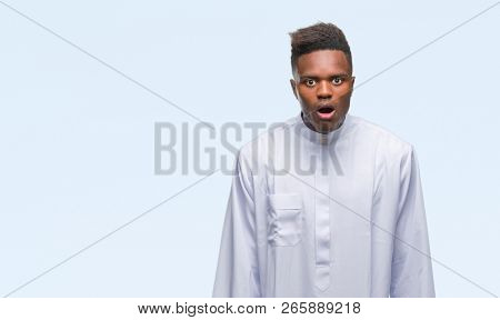 Young arabic african man wearing traditional djellaba over isolated background afraid and shocked with surprise expression, fear and excited face.