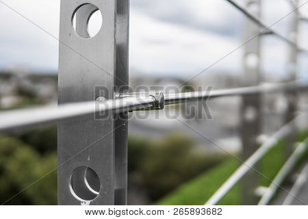 Details Of Fence Made Of Stainless Steel Profile With An Artificial Raffa On The Background.