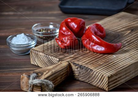 Spicy Red Pepers Lies On The Wooden Background.