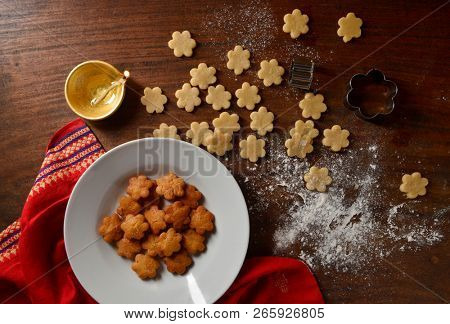 Delicious special snacks is being prepared during Diwali festival. Deep fried cookies or Shankarpali in a bowl with oil lamp, View from above.
