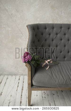 Pink Bouquet On A Grey Sofa. Bouquet Tied With Pink Ribbon Lying On A Grey Sofa