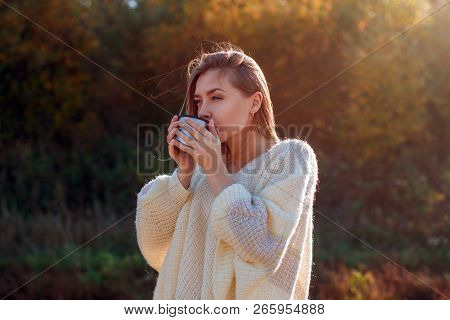 Beautiful Admiring Woman Drinking Hot Tea From Thermos Cup With Backligth Sun.