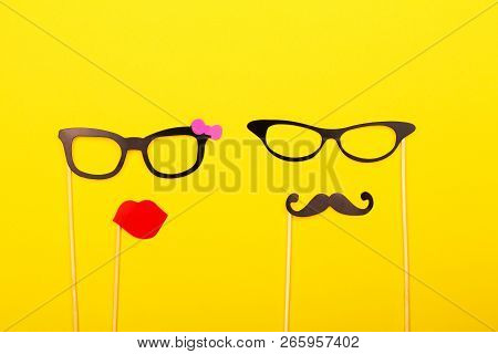 Male And Female Photo Booth Props On The Yellow Background. Wedding, Party Or Birthday Concept. Flat