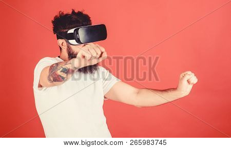 Virtual Racing Concept. Man With Beard In Vr Glasses Driving Motorbike, Red Background. Hipster On C