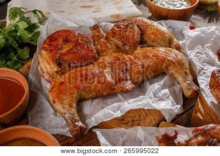 Gentle Chicken Tabaka On A Wooden Background With Sauces Of Different Types.