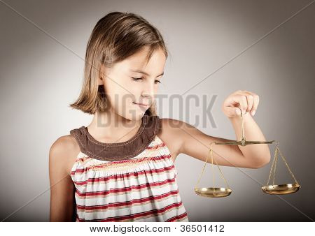 Little girl holding scala di giustizia