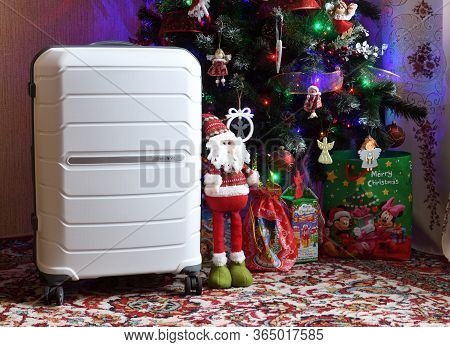 Belarus, Brest - January 9, 2020: A White Suitcase Samsonite Stands Near The Christmas Tree As A Gif