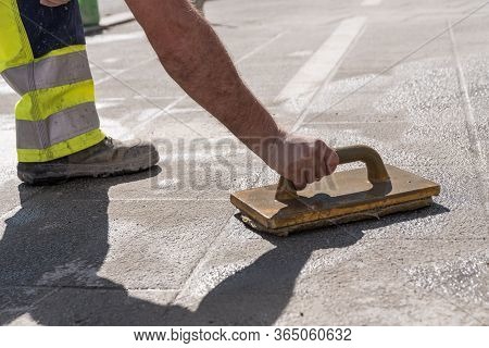 Road Workers With Tiler Tools At Work - Close-up Of Tiler