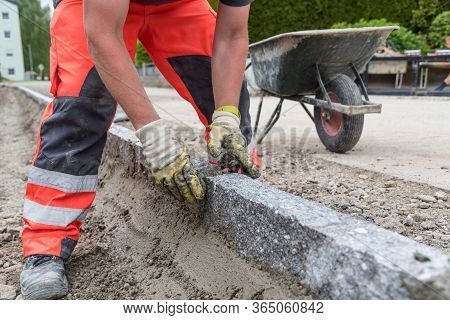 Road Workers With Mortar While Laying Curbs - Close-up Of Craftsman