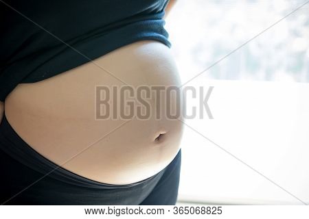 Close Up Pregnant Woman\'s Belly. Prenancy And Maternity Concept. Development Of Pregnancy And Fetus