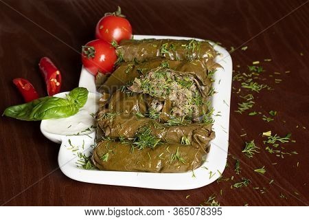 Caucasian Dolma Is A Dish Of Grape Leaves And Rice With Meat. Serving Dolma With Yogurt Sauce And Sp