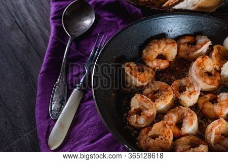 Fried Prawns In A Pan On A Table With Bread, Farm Serving Food, Dark Background. The Concept Of Nutr