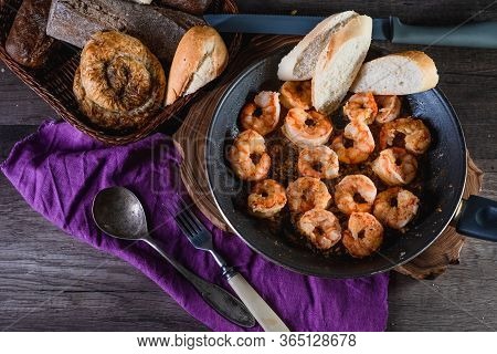 Fried Prawns In A Pan On A Table With Bread, Farm Serving Food, Dark Background. The Concept Of Nutr