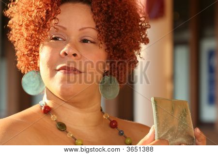 Mujer con cabello rizado rojo y joyas brillantes