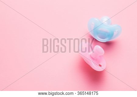 Silicone pacifier. Pink and blue baby pacifier on pink background.