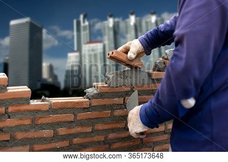 Wall Laying Bricks In Construction, On The Background Of The Buildingม Basic Concepts Of Constructio