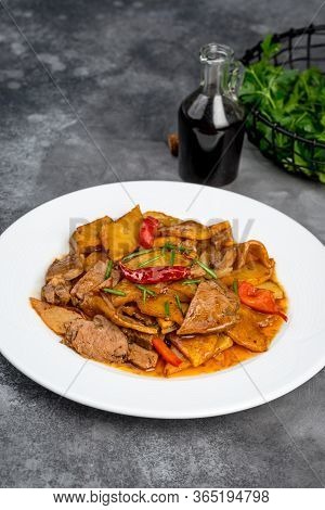 Braised Beef With Potatoes In A White Plate On A Gray Background